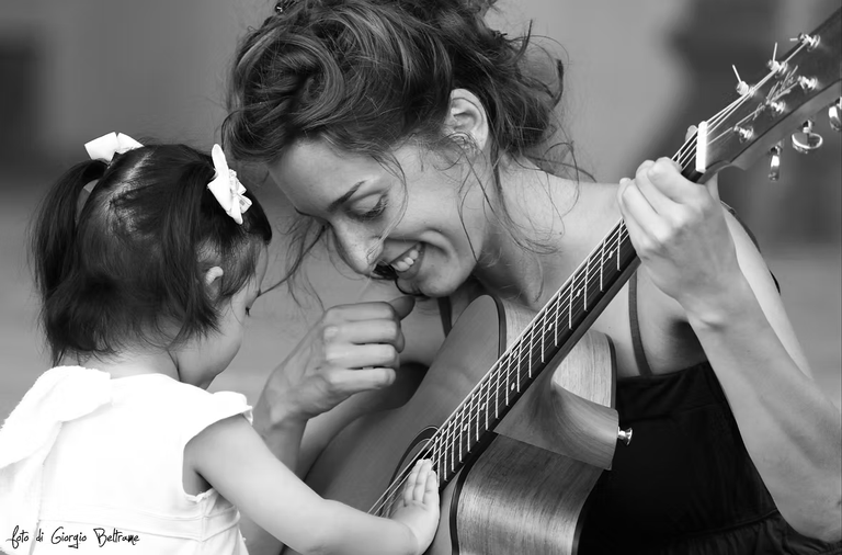 Susanna Roncallo guiding a student on acoustic guitar